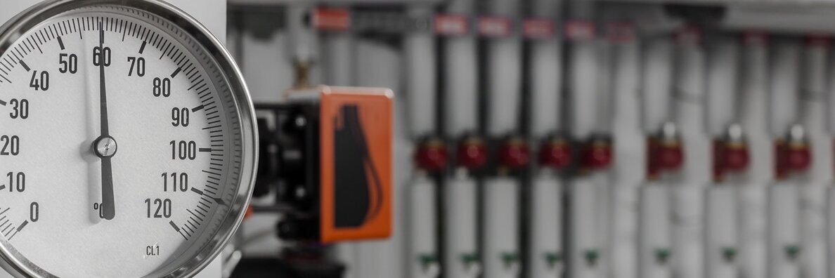 Rohrleitung einer Heizung im Heizungskeller mit Temperaturanzeige